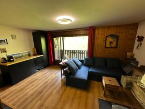 un soggiorno con un divano e un tavolo di Appartement style chalet a Cordon