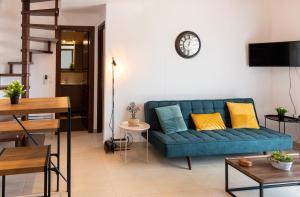 a living room with a blue couch and a table at Chris Luxury Loft in Kallithea Halkidikis