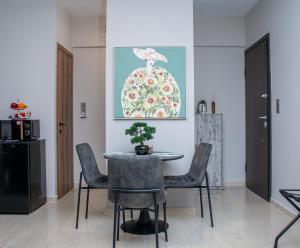 a dining room with a table and chairs and a painting at sweet suite in Missolonghi