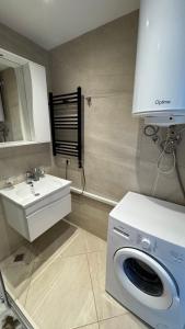 a bathroom with a washing machine and a sink at Hedi 18 Apartment in Batumi