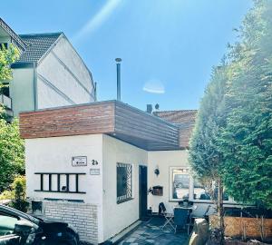 a small white house with a car parked in front of it at Schulz Apartments Siegburg in Siegburg