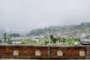 a view of a city from a brick wall at White Cabin By Travelink in Dieng