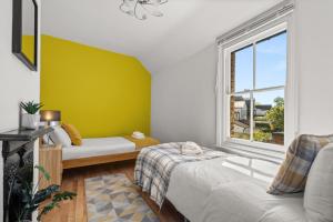 a small room with a bed and a window at Lovely 4 Bedroom London Home with Free Parking, Garden, WiFi By Roost Accommodation in Kingston upon Thames