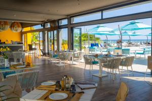 スースにあるSousse Pearl Marriott Resort & Spaの海の景色を望むテーブルと椅子付きのレストラン