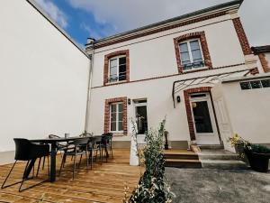 a patio with a table and chairs in front of a building at Les Tanins d 'Ay in Ay