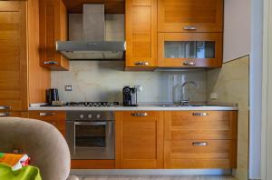 Una cocina con gabinetes de madera y un fregadero. en M Apartment in Rome, en Roma