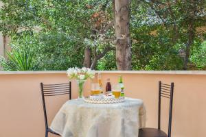 a table with two chairs and a vase of flowers at Excellence Suite in Rome