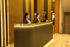 two women sitting at a counter in a lobby at Rest by Dedeman Elbistan in Elbistan
