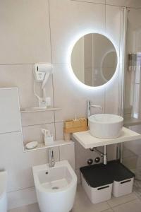 a white bathroom with a sink and a mirror at Tra Lago Maggiore e lago d'Orta Appartamento TERRA in Colazza