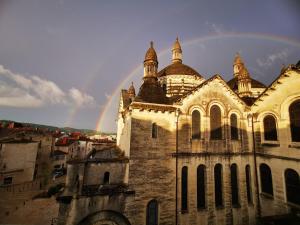 a rainbow in the sky above a large building at Gite du Clocher de la Cathédral charmant duplex in Périgueux