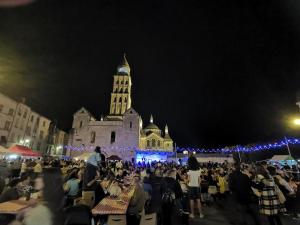 a crowd of people sitting at tables in front of a building at Gite du Clocher de la Cathédral charmant duplex in Périgueux