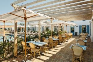 a row of tables and chairs under umbrellas at a restaurant at La Mission Hôtel & SPA - l'île d'Yeu in L'Ile d'Yeu