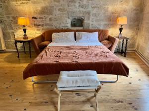 a large bed in a living room with a couch at Gite du Clocher de la Cathédral charmant duplex in Périgueux +12 photos