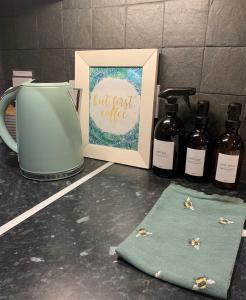 a picture and some bottles of wine on a counter at Cysgod Bach & Caban y Saer Cottages in Bala