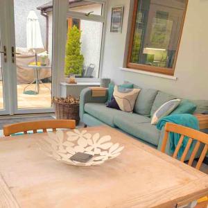 a living room with a blue couch and a table at Cysgod Bach & Caban y Saer Cottages in Bala +32 photos