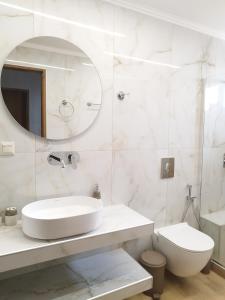a white bathroom with a sink and a toilet at Christina's Home in Sarti +12 photos