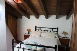 una camera da letto con letto nero e 2 comodini di La Chimenea de Soria I y I I a Espeja de San Marcelino