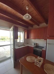 a kitchen with wooden cabinets and a table with a table at 3-Bedroom House with Loft in Corfu by ΜΡS in Agios Georgios