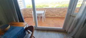 a room with a table and a balcony with a view of a patio at Sol e Praia Alvor 1 in Alvor