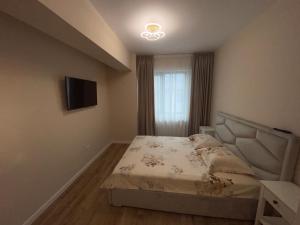 a small bedroom with a bed and a television at Ayan Mamaia in Mamaia Nord