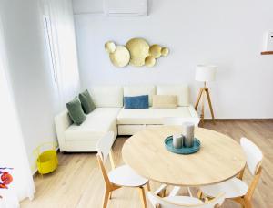 a living room with a table and a couch at Alojamiento Erytheia, tranquilo, a 150 metros de la playa y pleno casco histórico in Conil de la Frontera