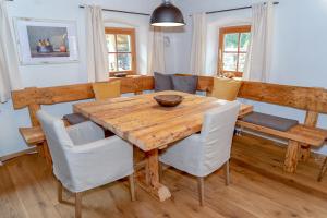 a dining room with a wooden table and chairs at Obiralmhütte Mosgan in Bad Eisenkappel