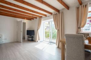 Una sala de estar con una mesa y un televisor. en Morton Cottage, en Thornhill