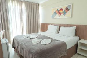 a hotel room with a bed with bows on it at Conde Hotel Maceió in Maceió