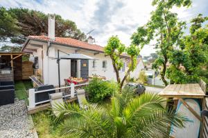 a house with a patio with an umbrella at Capbreton Surf House in Capbreton