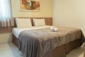 a bedroom with a bed with two towels on it at Conde Hotel Maceió in Maceió