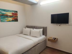 a bedroom with a bed with a flat screen tv on the wall at Kazi Castle in Rāmchandrapur