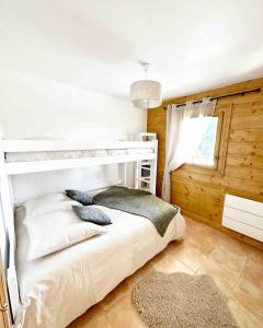 a bedroom with a bunk bed and a window at L'Ourson aux pieds des pistes & piscine chauffée in Crest-Voland