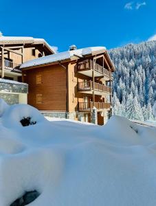 a building with snow in front of it at L'Ourson aux pieds des pistes & piscine chauffée in Crest-Voland