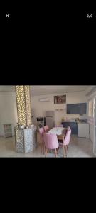 a living room with a table and chairs and a kitchen at Arous jabal in Ksar es Sghir