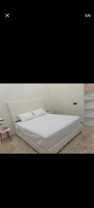 a bedroom with a white bed and a table at Arous jabal in Ksar es Sghir