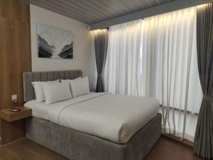 a bedroom with a large bed in front of windows at Kazi Castle in Rāmchandrapur