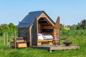 a play house with a bed and chairs in a field at La Tiny House de l'Ouchette in Brégy
