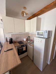 een keuken met een witte koelkast en een magnetron bij T2 Cosy HYPER CENTRE AJACCIO in Ajaccio