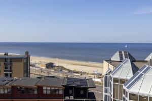 Blick auf einen Strand mit Gebäuden und das Meer in der Unterkunft NH Zandvoort Hotel in Zandvoort