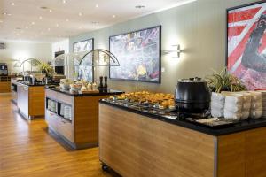 eine Küche mit einer Theke mit Essen darauf in der Unterkunft NH Zandvoort Hotel in Zandvoort + 37 Fotos