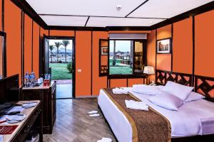 a bedroom with a large bed with orange walls at Xperience Golden Sandy Beach in Sharm El Sheikh