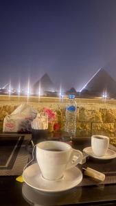 - une table avec une tasse de café et une bouteille d'eau dans l'établissement City pyramids inn, au Caire