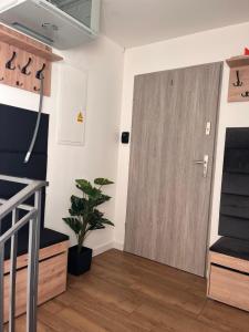 a room with a wooden door and a plant at Dotin dom in Zagnańsk