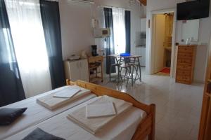 a bedroom with a bed and a kitchen with a table at Kata in Nin