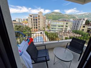 zwei Stühle und ein Tisch auf einem Balkon mit Aussicht in der Unterkunft Apartment ENJOY in Bar