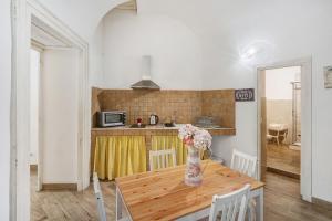 a kitchen with a wooden table with a vase of flowers at Aparthotel in pieno centro storico in Naples