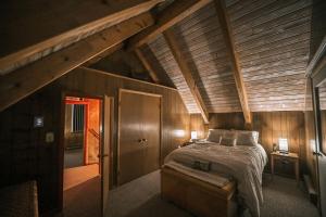 una camera da letto con un letto con soffitto in legno di Rustic Cabin Rental with a Hot Tub near Windham, New York a Windham Altre 32 foto