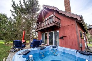 una vasca idromassaggio davanti a una casa rossa di Rustic Cabin Rental with a Hot Tub near Windham, New York a Windham