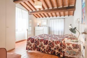 コルトーナにあるBorgo La Fonte - Together in Tuscanyのベッドルーム1室(花柄のベッドカバー付) +7枚の写真