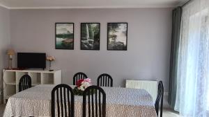 a dining room with a table and four pictures on the wall at ALDAMI in Warsaw